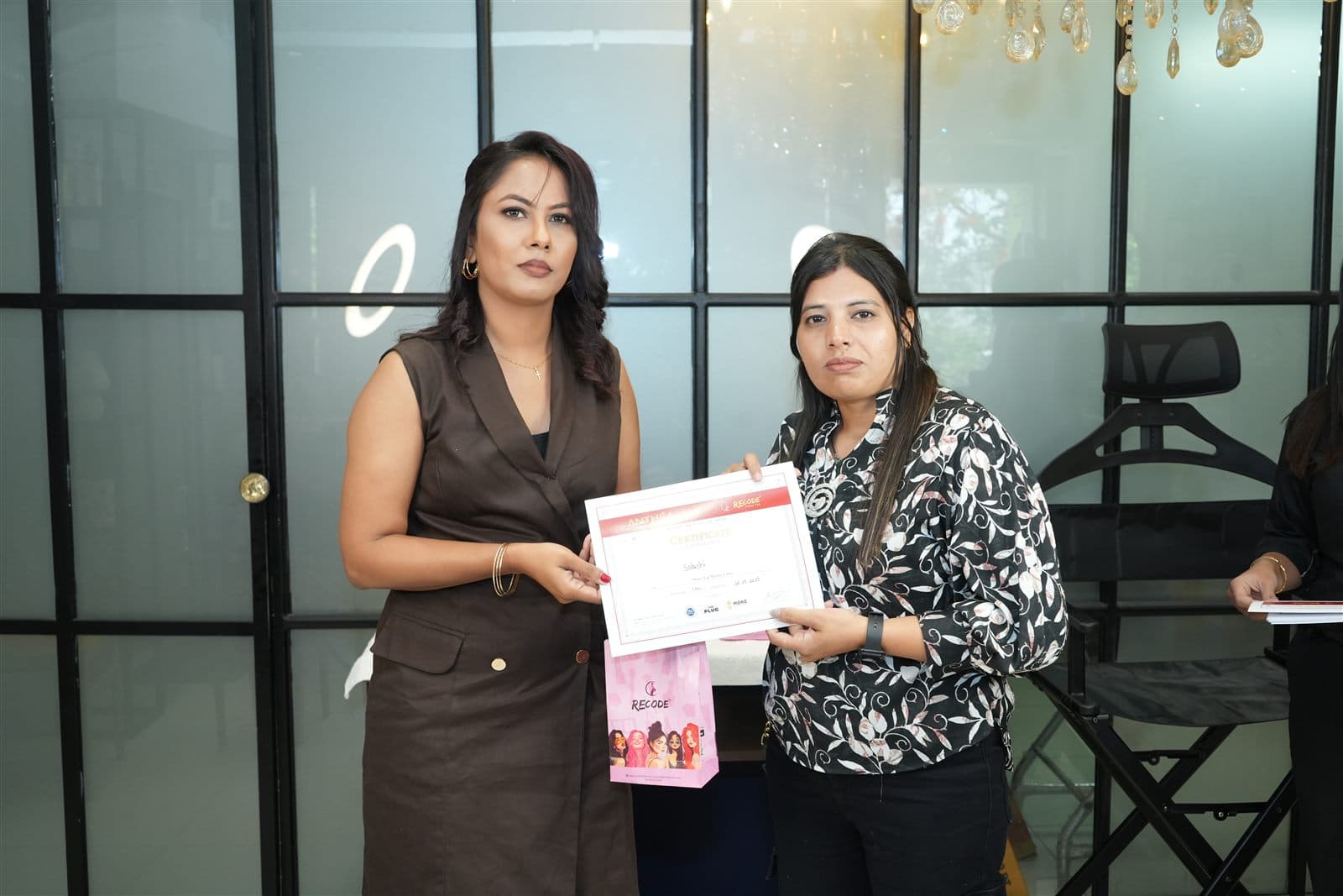 A student receiving her certificate from Anthéa at the Academy