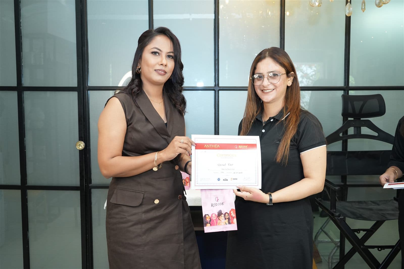 A student receiving her certificate from Anthéa at the Academy