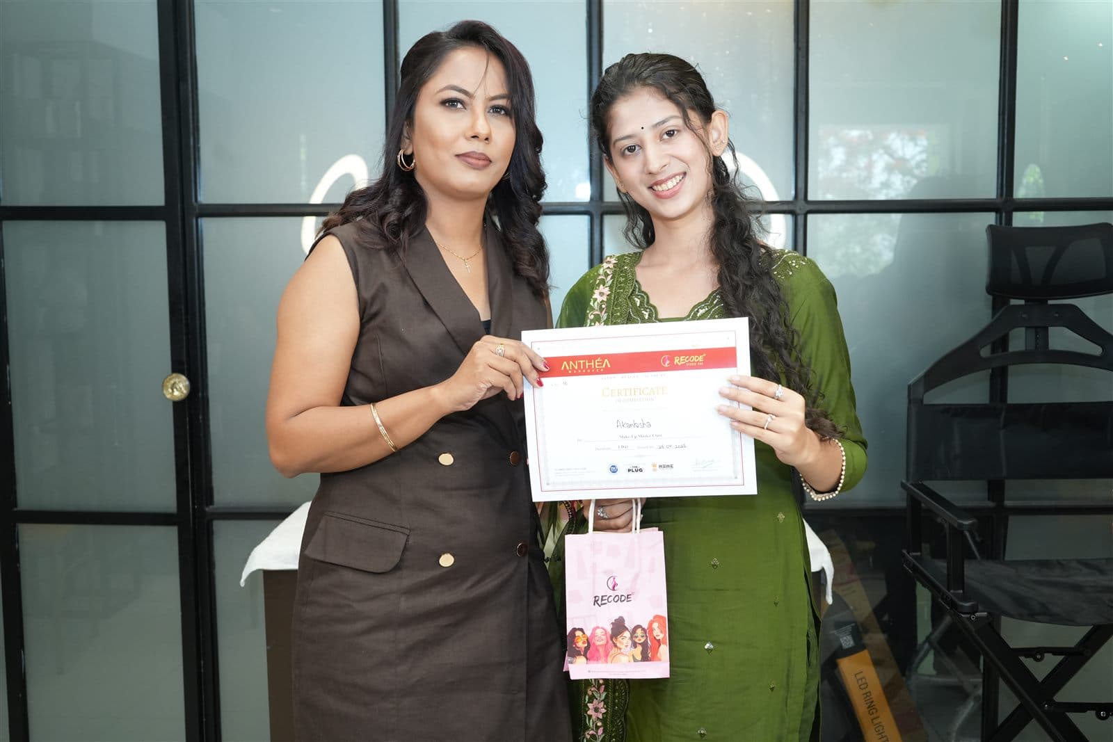 A student receiving her certificate from Anthéa at the Academy