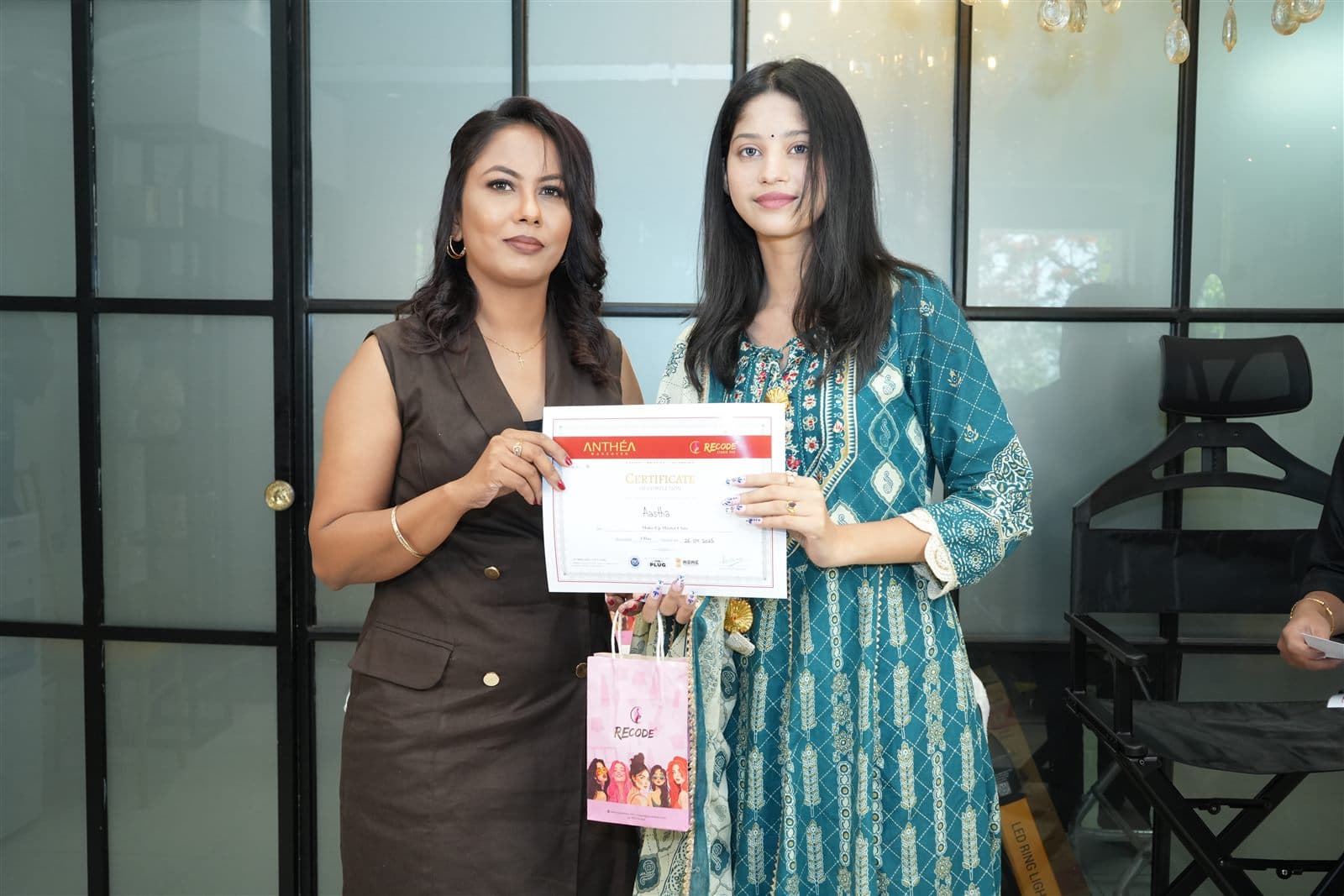 A student receiving her certificate from Anthéa at the Academy