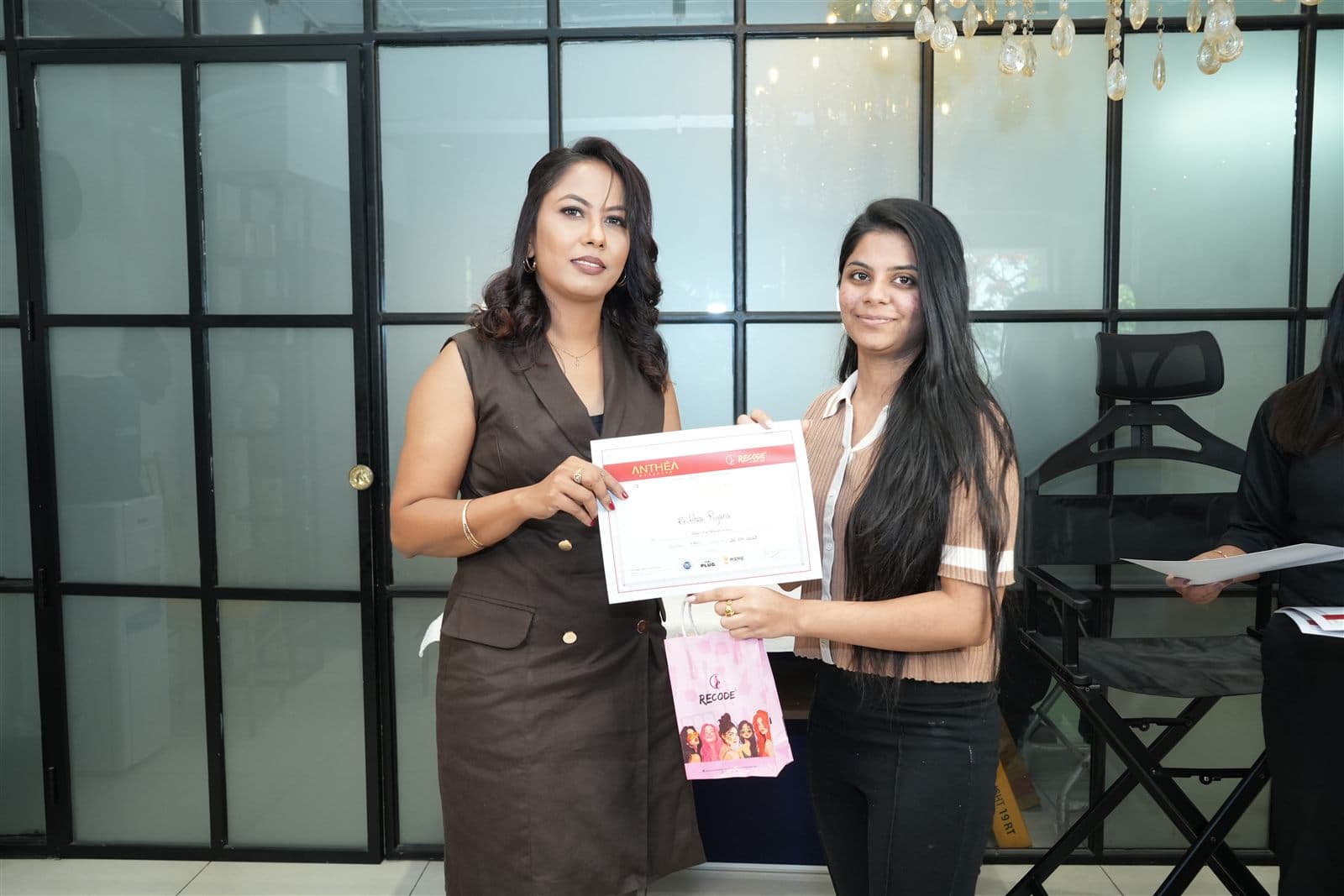 A student receiving her certificate from Anthéa at the Academy