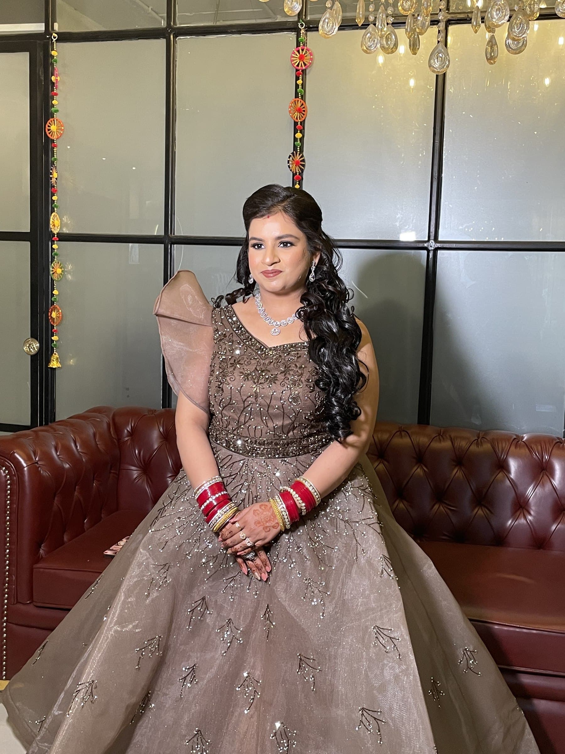 A bride in a blush tulle gown seated beneath a marigold backdrop