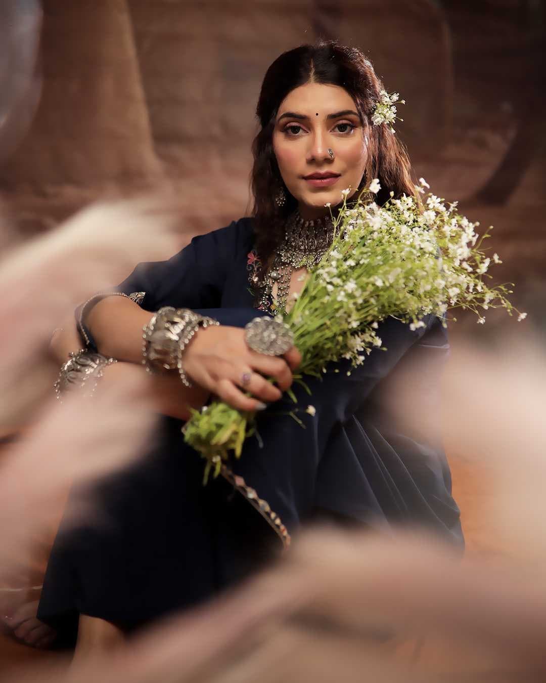 A bride in midnight blue holding a bunch of baby's breath