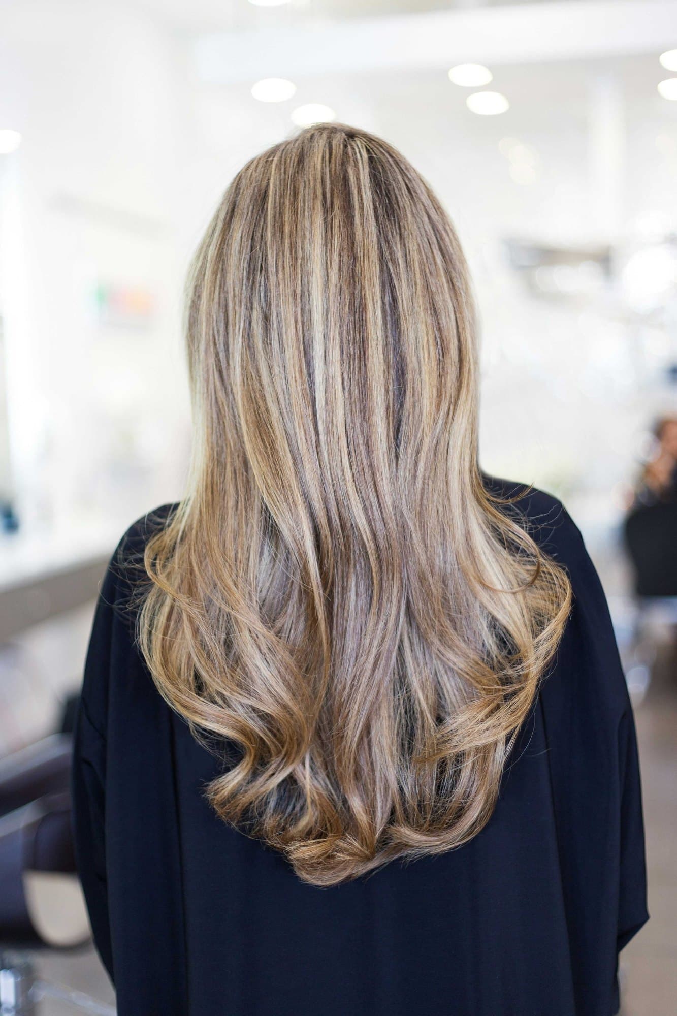 Long, freshly blow-dried hair seen from behind in the salon
