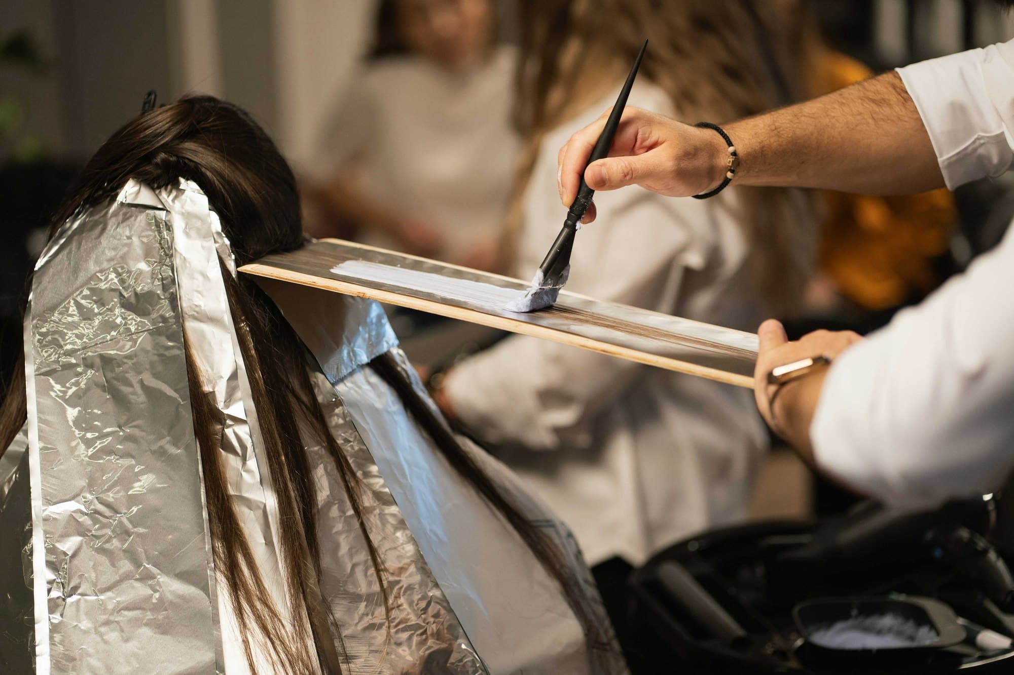 A colourist working in gloves with clean foils and a fresh brush